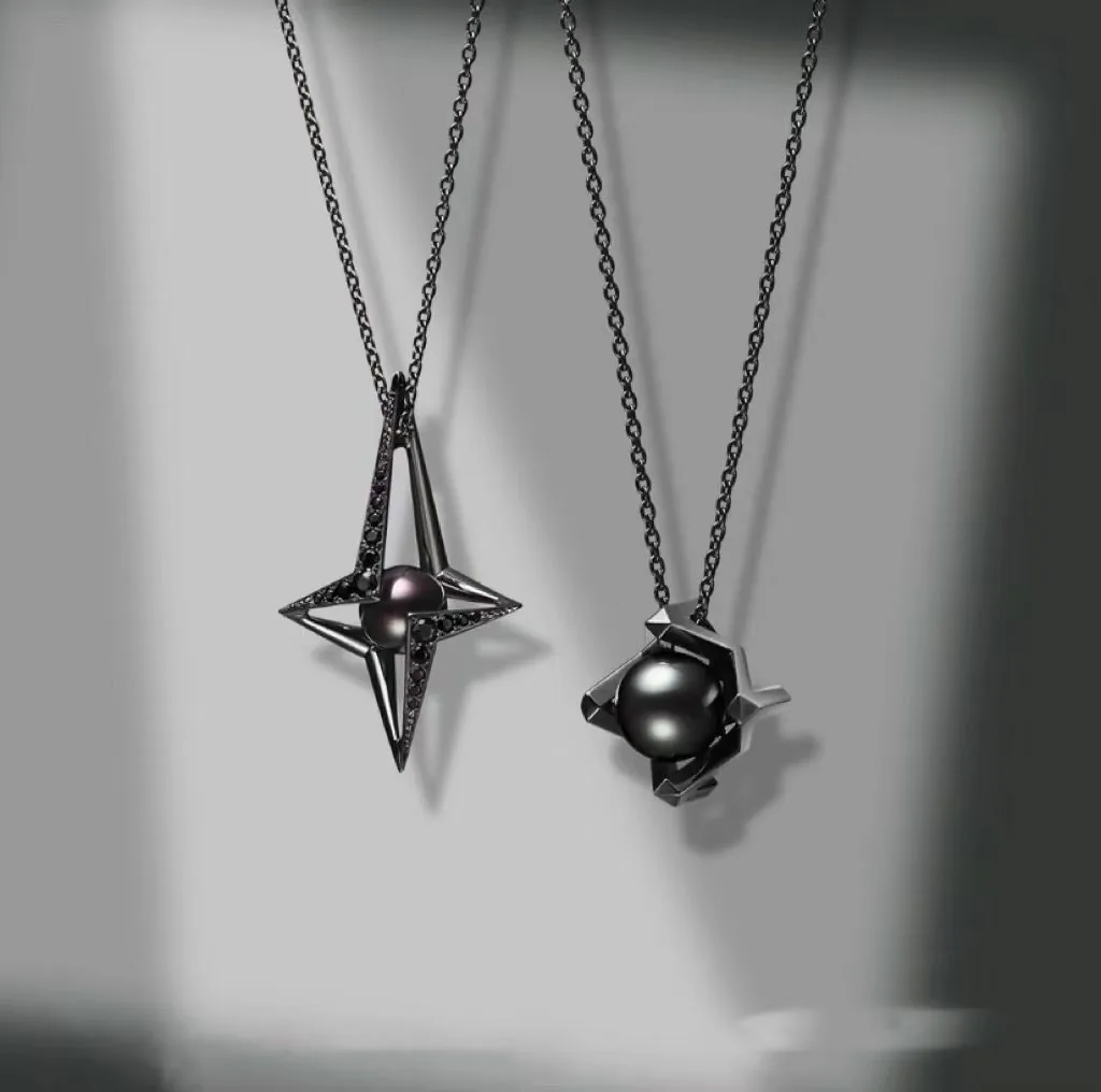 Two dark pearl pendants held in open geometric metal cages