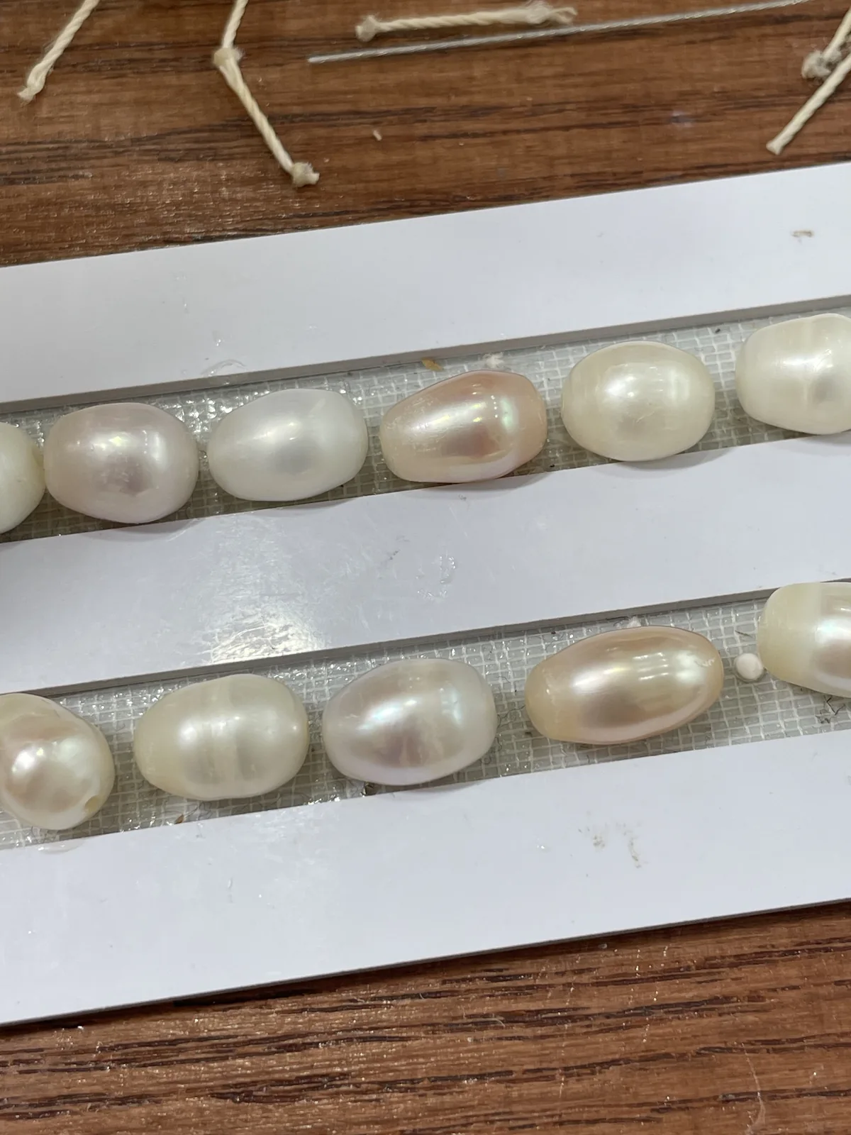 Drilled baroque pearls in a tray, with uneven surface texture from pearl to pearl