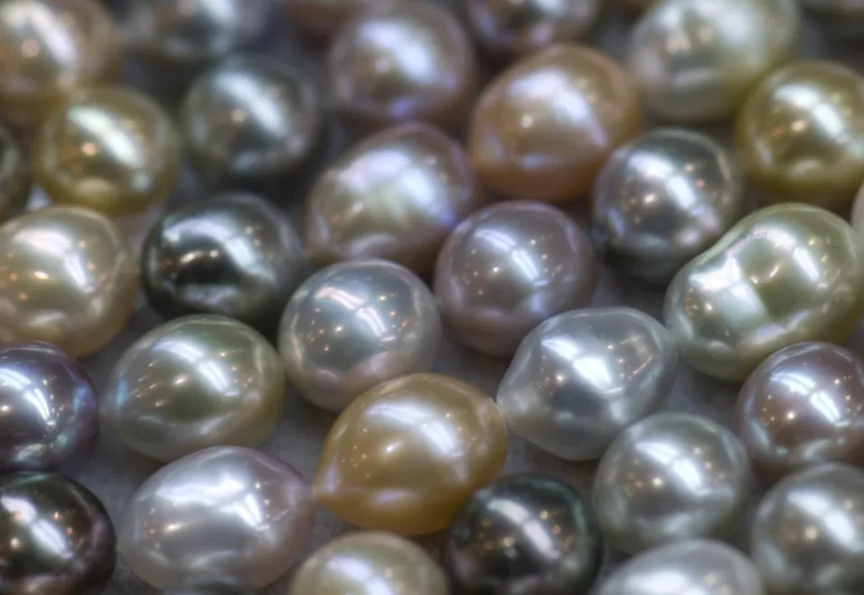 Close view of irregular cultured pearls in silver, gold, cream, and gray